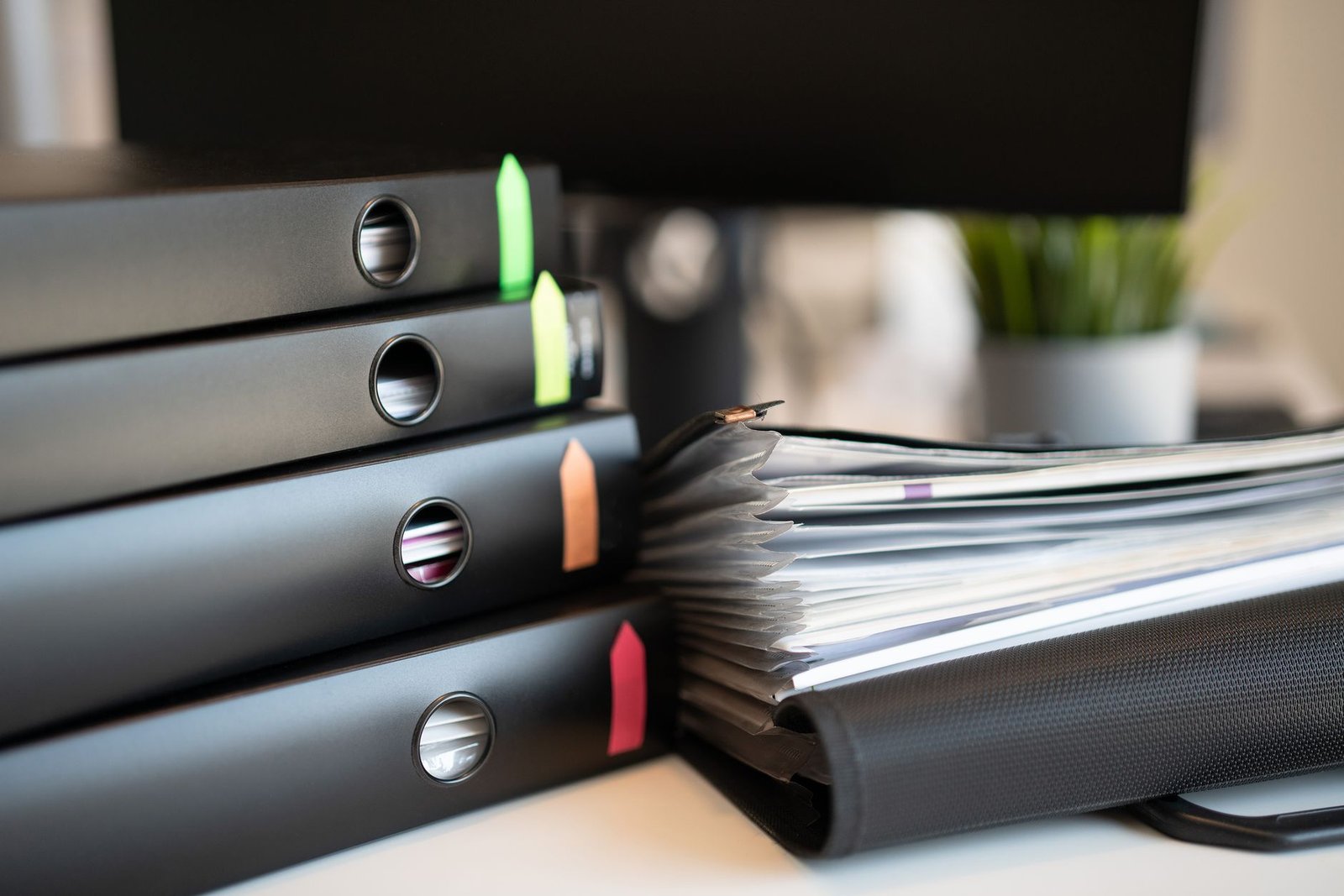 Stack of ring binders and documents on a desk