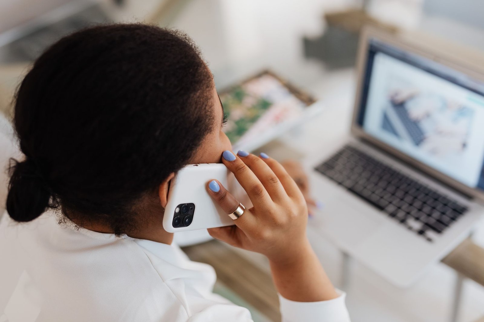 Person making a phone call while working at a laptop
