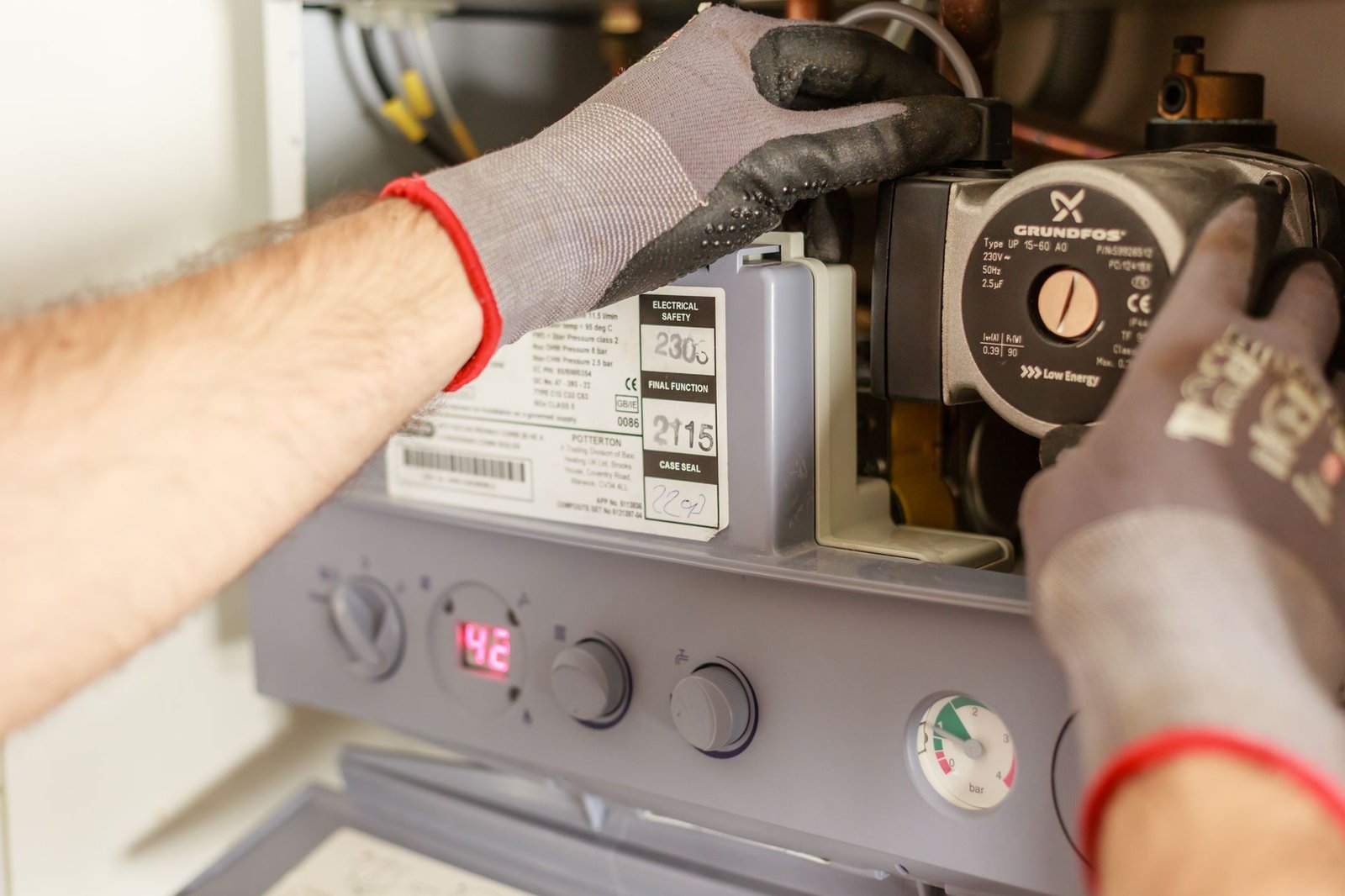 Close-up of hands adjusting heating system instrumentation
