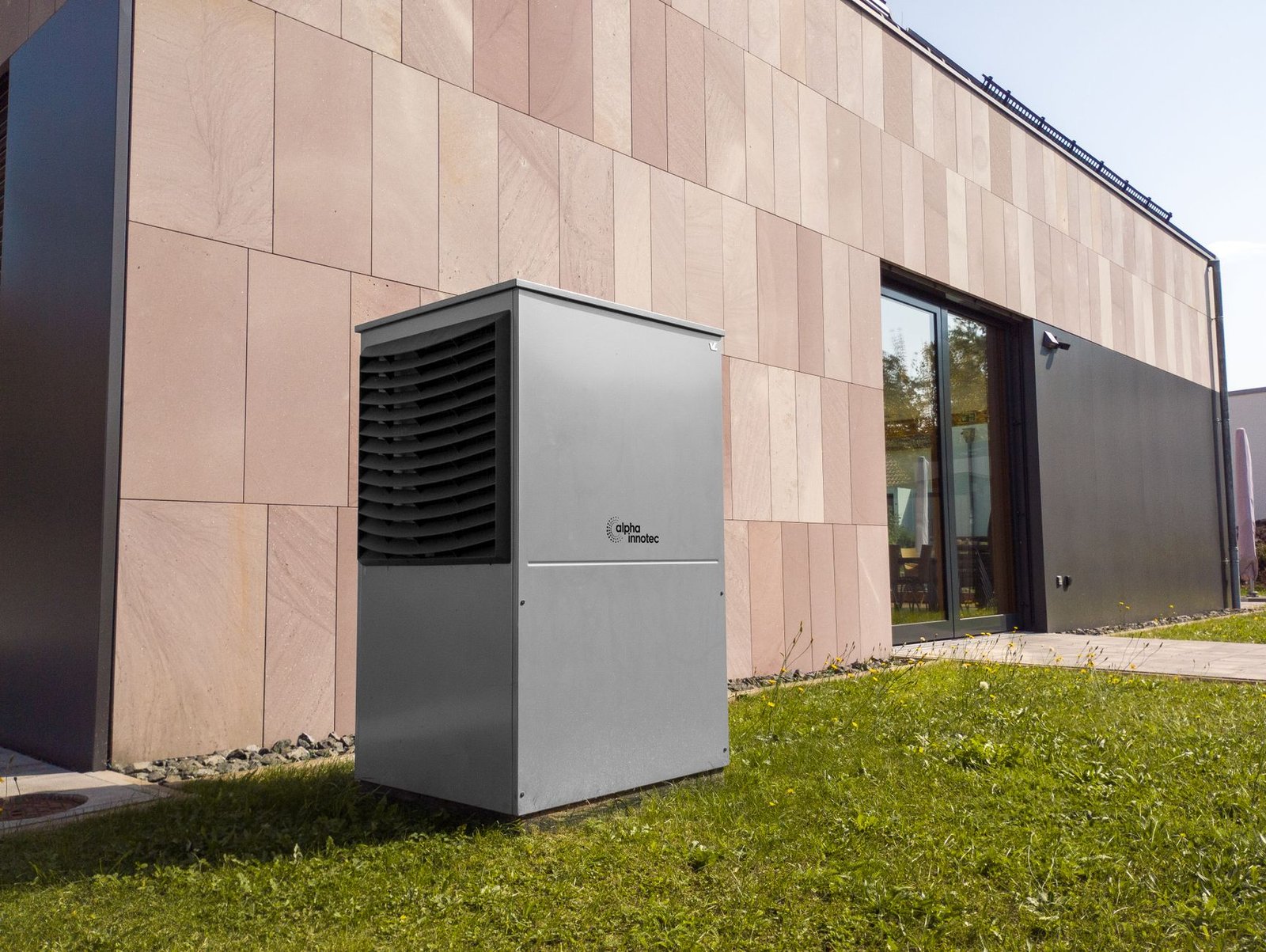 Modern outdoor heat pump condenser installed beside a residential building