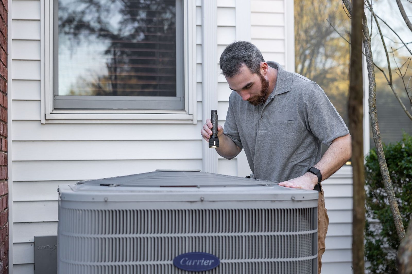 HVAC technician inspecting an outdoor ductless unit